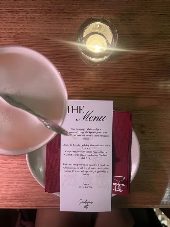 The Menu dinner card on candlelit table